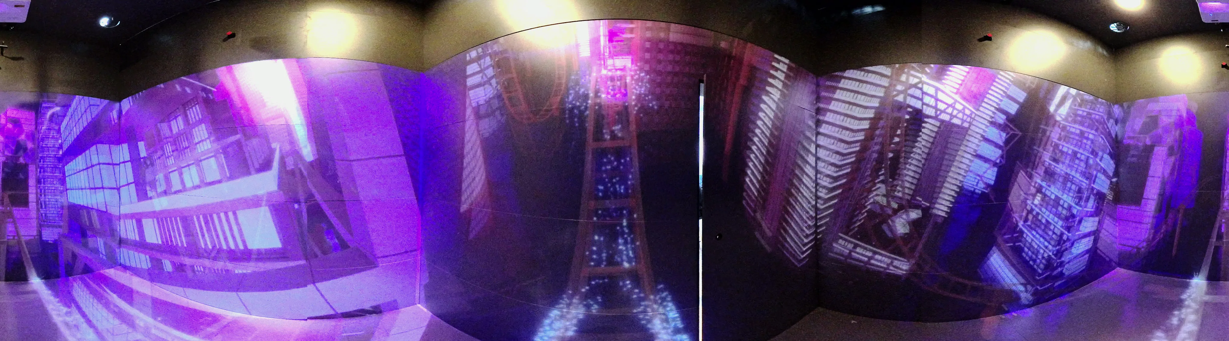 Panorama of the room: a violet cyber city across every wall