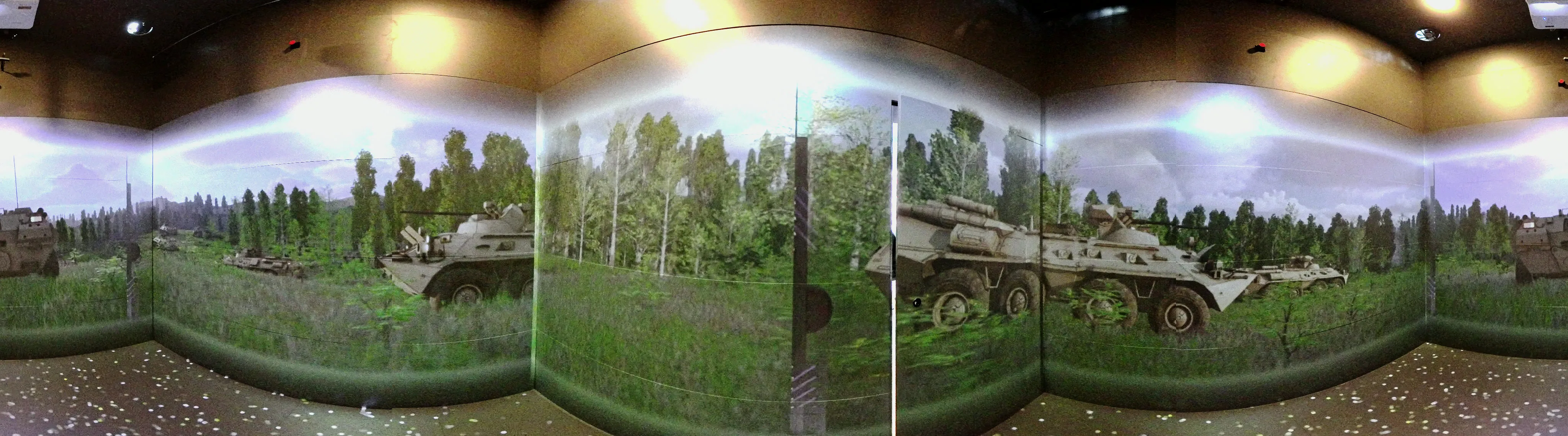 Panorama of the room: a forest with armoured vehicles on the walls, screens on the far wall