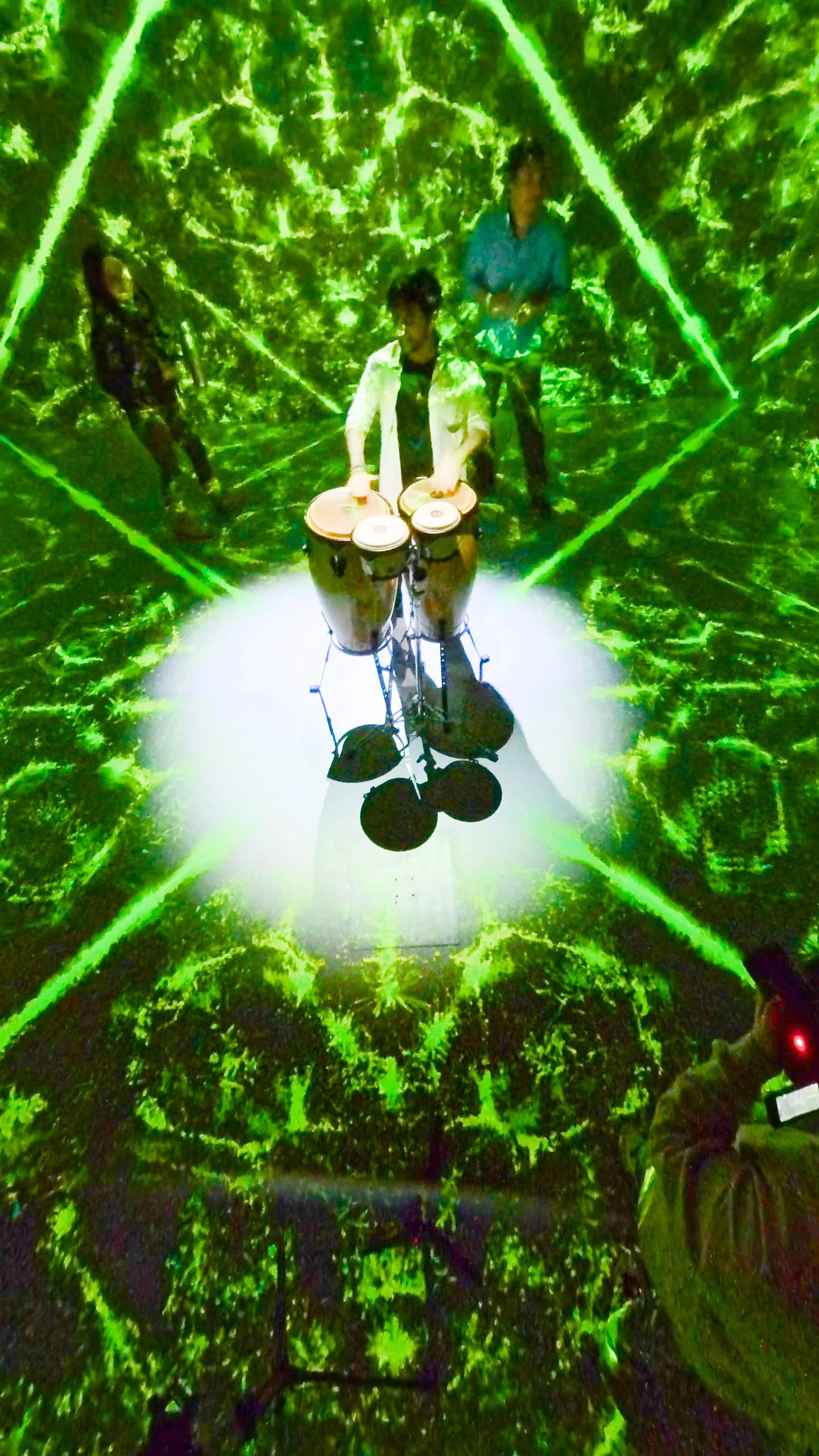 Seen from above: the percussionist at the centre of a green kaleidoscopic floor