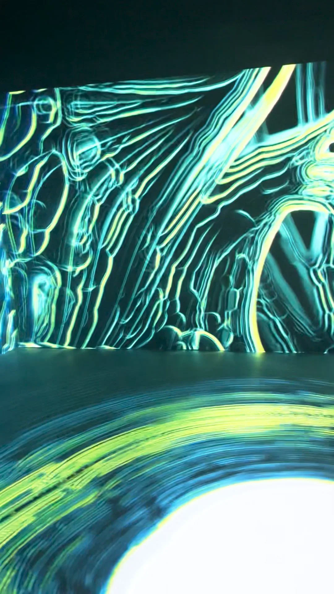 Yellow and cyan line patterns on the wall, a white arc of light spreading across the floor