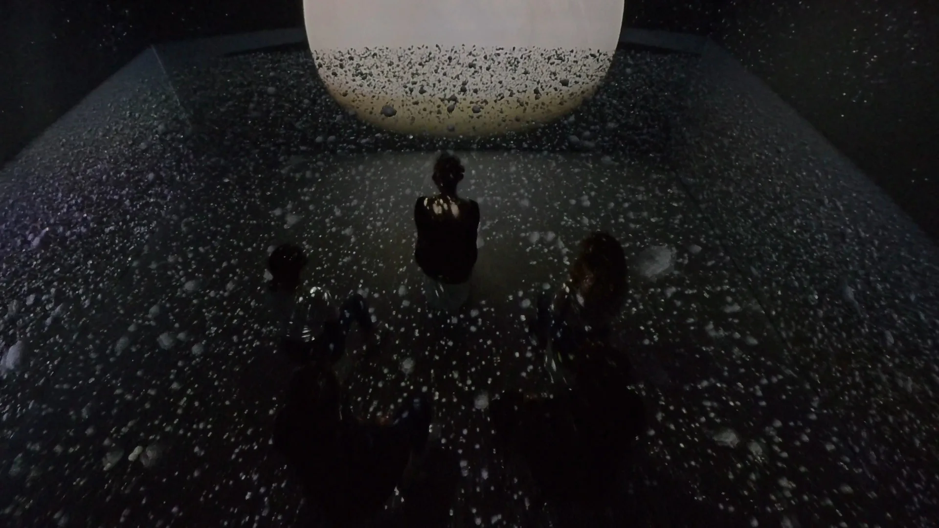 Seen from above: visitors on a floor of drifting particles beneath the bright disc of Uranus